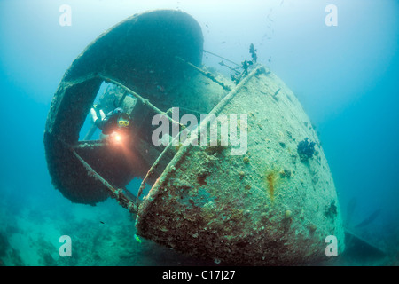 Un subacqueo scende attraverso una apertura sulla poppa gun emplacement del Thistlegorm naufragio nel Mare Rosso Golfo di Suez. Foto Stock