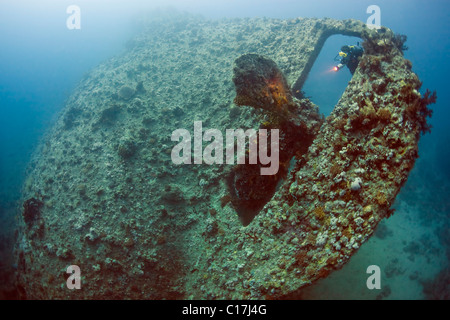 Un subacqueo brilla la propria torcia sull'elica del Dunraven naufragio sulla punta meridionale del Sinai nel Mar Rosso egiziano. Foto Stock