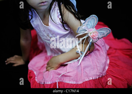 Bambina di cinque anni in abito rosa con farfalla bacchetta e ali di fata Foto Stock