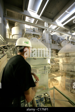 Lavoratore con materie Mills, nel quale pietrisco diventa fine polvere grigia, produzione di cemento nel cemento Schwarzenfeld di fabbrica Foto Stock