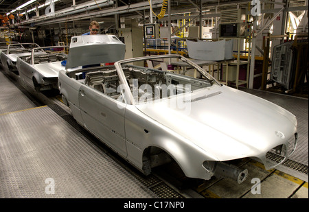 Un operaio di fabbrica di assemblare il tronco di una serie 3 Bmw cabriolet sul telaio dello stabilimento di assemblaggio nel BMW AG in fabbrica Foto Stock