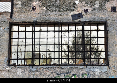 Parete in cemento e la vista dalla finestra rotta di fabbrica abbandonata. Foto Stock