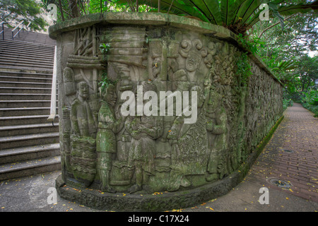 Balinese parete in pietra le sculture nel parco di Fort Canning Singapore 2 Foto Stock