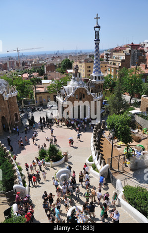 Ingresso principale cortile pieno di visitatori e con vista panoramica a Barcellona città in una delle principali mete turistiche luoghi - Parco Guell Foto Stock