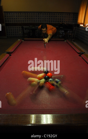 Snooker player prendendo un colpo lungo tutta la tabella Foto Stock