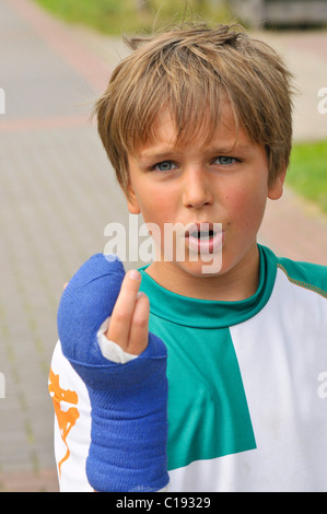 Ragazzo con uno spezzato dita e gesso sulla sua mano Foto Stock