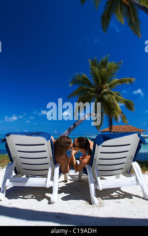 Coppia romantica seduto accanto a Palm tree Foto Stock