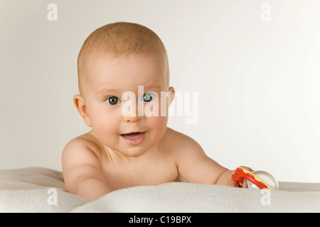 Baby, 6 mesi di età, giocando con un sonaglio Foto Stock