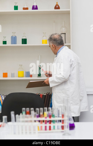 Scienziato facendo esperimento scientifico in un laboratorio Foto Stock