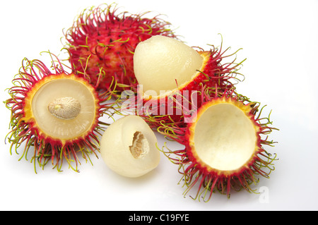 Pelosi, Rambutan rosso frutto (Nephelium lappaceum). I frutti interi, alcuni pelati, mostrando bianco carne commestibile e sementi. Girato in bianco. Foto Stock