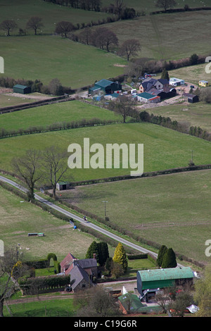 Guardando ad ovest dalla sommità del lungo intervallo Mynd al solitario cavaliere a cavallo sul vicolo del paese vicino Asterton Shropshire, Inghilterra, Regno Unito Foto Stock