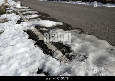 La neve sulla strada asfaltata nascondere le righe bianche Foto Stock