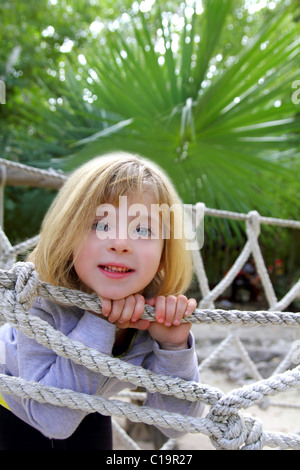 Avventura felice bionda bambina a jungle park ponte di corde Foto Stock