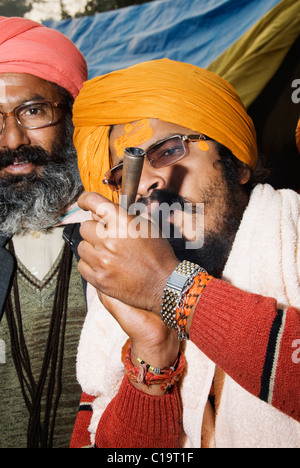Sadhus fumare una chilam, Haridwar, Uttarakhand, India Foto Stock