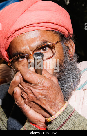Close-up di un sadhu fumare una chilam, Haridwar, Uttarakhand, India Foto Stock