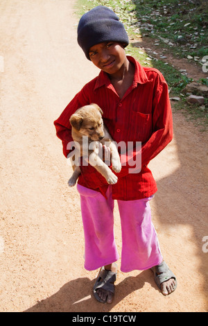 Ritratto di un ragazzo che porta un cucciolo, Orchha, Madhya Pradesh, India Foto Stock