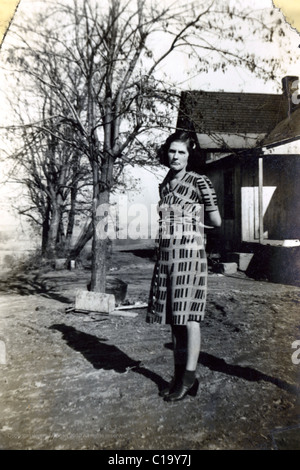 Ritratto di donna in abiti sul farm nella metà degli anni quaranta durante la seconda guerra mondiale era Indiana depressione era cascina Moda scarpe da donna triste infelice Foto Stock