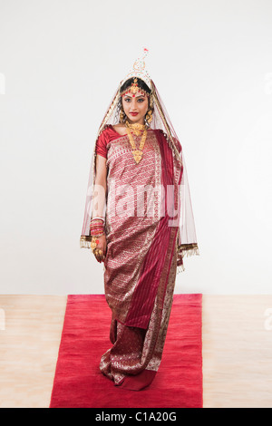 Sposa in lingua bengalese vestito in piedi su un tappeto Foto Stock