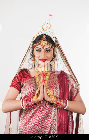 Sposa in lingua bengalese vestito in piedi in posizione di preghiera Foto Stock