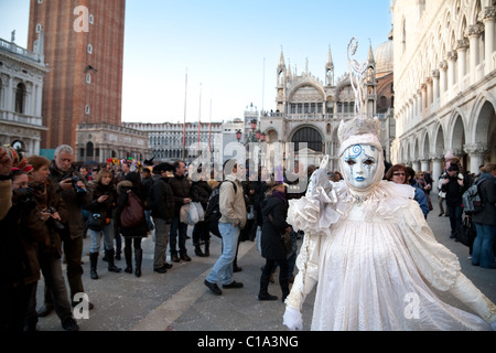 Un modello di posa per la folla in piazza San Marco, il carnevale di Venezia, Venezia Italia Foto Stock