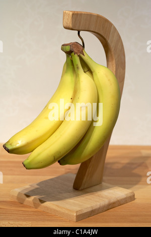 La maturazione delle banane appeso ad una banana in legno appendiabiti Foto Stock