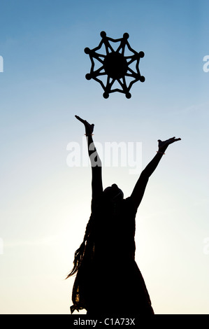 Silhouette ragazza indiano gettando un simbolo di one world, l unità e l'umanità nell'aria. India Foto Stock