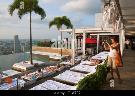 Donna di fotografare la piscina presso il Marina Bay Sands SkyPark. Il Marina Bay, Singapore Foto Stock