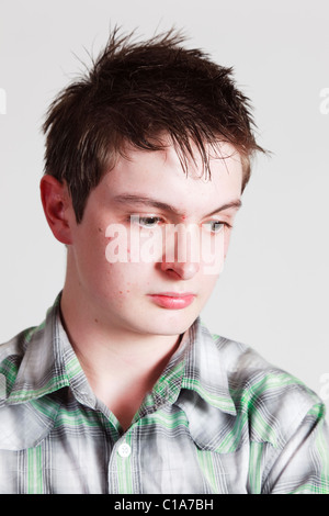 Testa e spalle il ritratto di un ragazzo adolescente guardando triste. Regno Unito, Gran Bretagna. Foto Stock