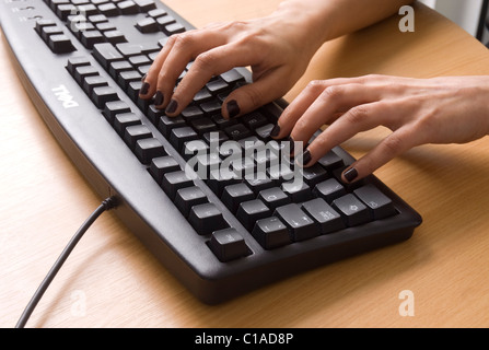 La digitazione sulla tastiera di un computer Foto Stock