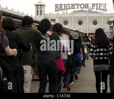 Le persone che hanno preso parte ad uno speciale Congathon intorno al molo di Brighton sperando per impostare un nuovo record del mondo e sollevare il pagamento in contanti per Macmillan Foto Stock