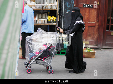 Una donna negozi a Whitechapel, East London - 27 Luglio 2010 - indossando un berka (Burqa). Foto Stock