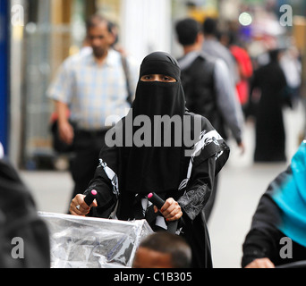 Una donna negozi a Whitechapel, East London - 27 Luglio 2010 - indossando un berka (Burqa). Foto Stock