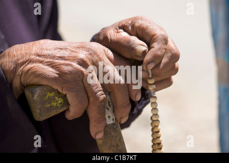 Uomo vecchio con le mani i grani di preghiera, durante un festival (Abate il compleanno), Phayang Gompa, (Ladakh) Jammu e Kashmir India Foto Stock