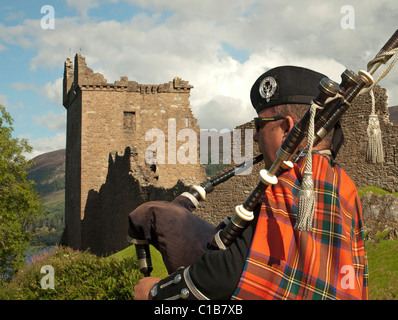 Professional cornamuse giocatore giocare la cornamusa al di fuori del Castello Urquhart, Loch Ness e Highlands scozzesi Foto Stock