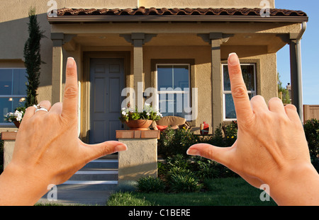 Mani femminili il framing bella recentemente costruita casa. Foto Stock