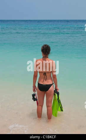 Donna che guarda al mare su Tegal polarizzazione Spiaggia di Padang Bai a Bali Indonesia Foto Stock