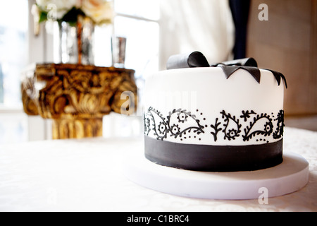 Elegante torta nuziale bianca con decorazione al cioccolato, meringhe e  macaroon su sfondo grigio Foto stock - Alamy