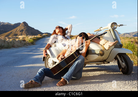 Le donne in appoggio su strada con moto Foto Stock