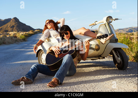 Le donne in appoggio su strada con moto Foto Stock