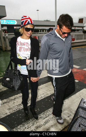 Paris Hilton e Doug Reinhardt che arrivano all'aeroporto. Parigi è stata indossando un britannica union jack hat e siamo arrivati con un 'Parigi Foto Stock