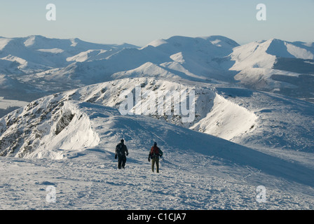 Walkers sul crinale del vertice della coperta di neve Blencathra in inverno nel Lake District inglese. Derwent Fells in background Foto Stock