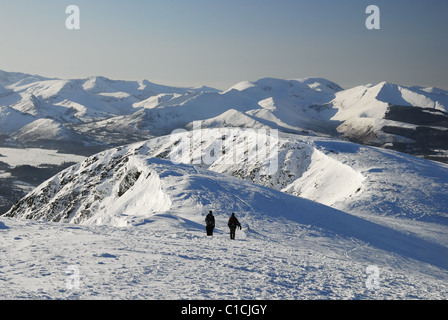 Walkers sul crinale del vertice della coperta di neve Blencathra in inverno nel Lake District inglese. Derwent Fells in background Foto Stock