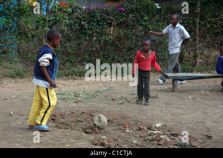 I bambini orfani che giocano a calcio/calcio nella città di Stati Uniti d'America fiume vicino a Arusha in Tanzania Foto Stock