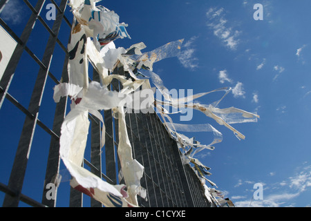 Poster strappato battenti nel vento sulla recinzione in città città Foto Stock