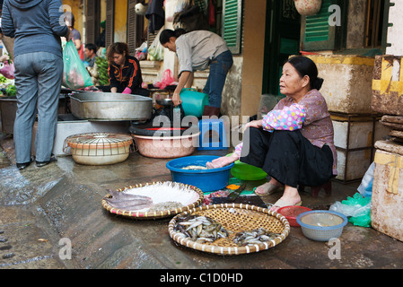 Una vecchia donna vende pesce fresco in local street market, Hanoi, Vietnam Foto Stock