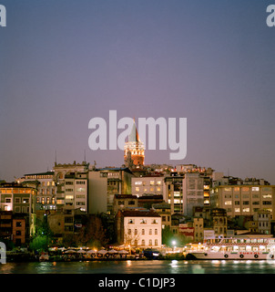 Un crepuscolo vista attraverso il Golden Horn per Karakoy e la Torre di Galata ( Galata Kulesi ) di Istanbul in Turchia. Foto Stock