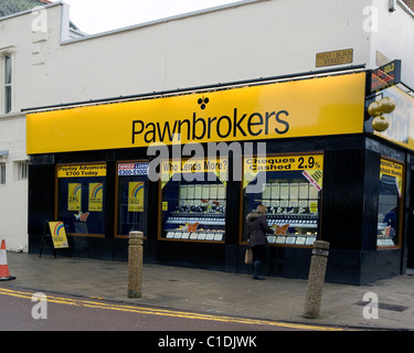 Pawnbroker negozio con donna cerca nella finestra Foto Stock