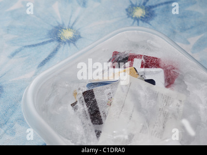 Carte di credito congelato in un contenitore di plastica Foto Stock
