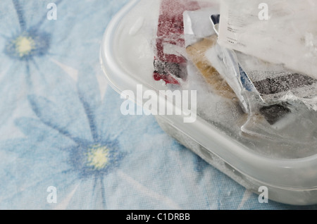 Carte di credito congelato in un contenitore di plastica Foto Stock