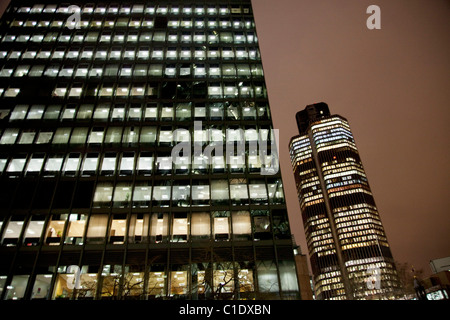 Tempo di notte in scena la città di Londra. Torre 42, aka il Nat West Tower, uno dei più alti, accanto a un altro blocco di uffici. Foto Stock